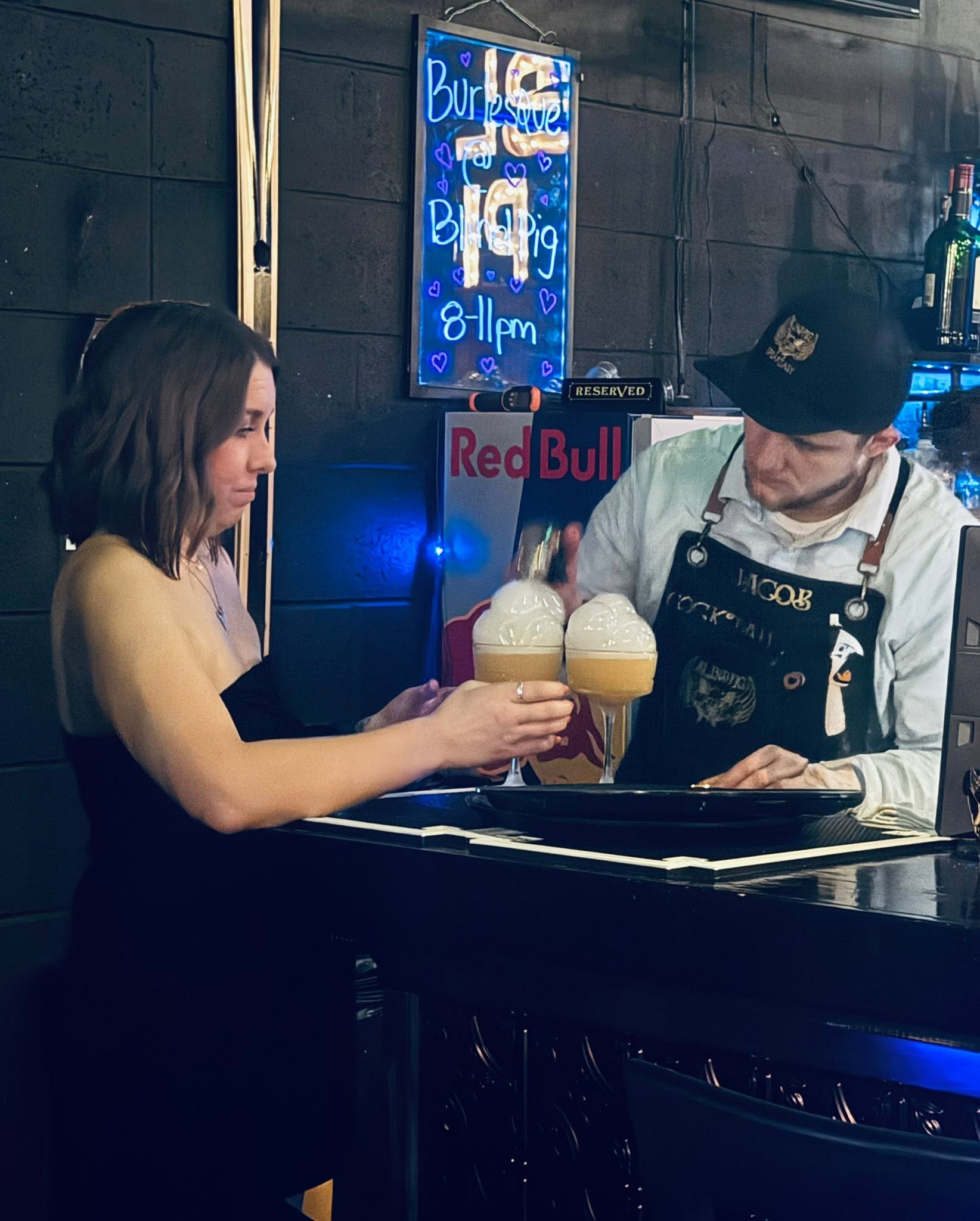 Bartender serving a craft cocktail to a guest at The Blind Pig bar.