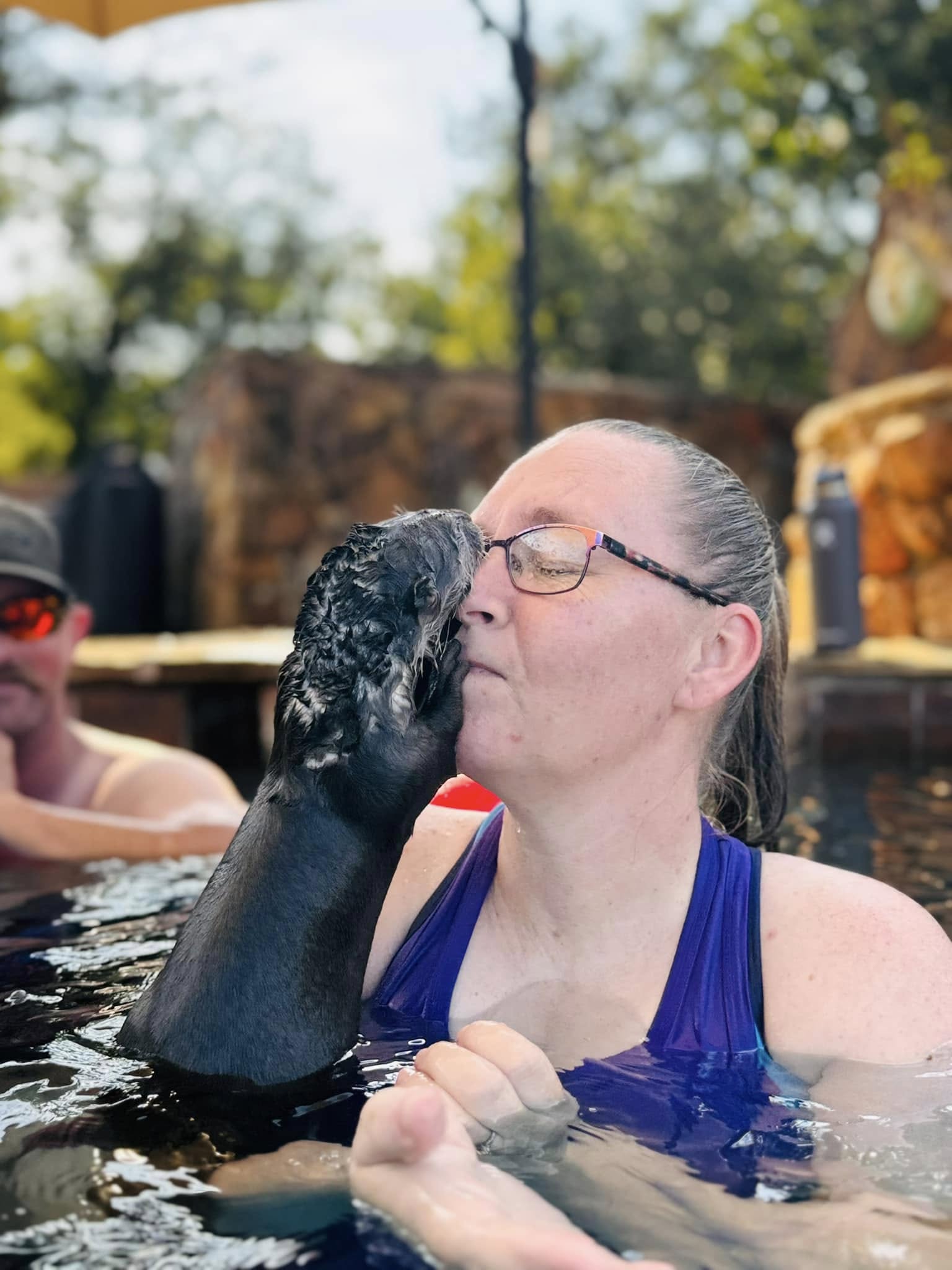 A guest sharing a joyful moment with one of the otters