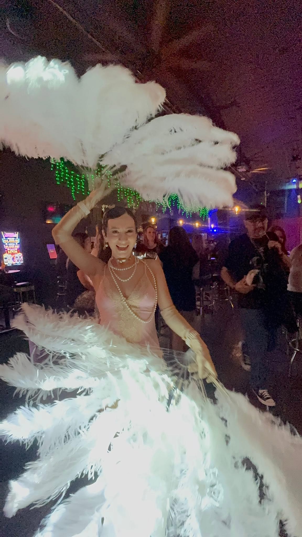 Burlesque performer in feathered fans on stage at The Blind Pig.